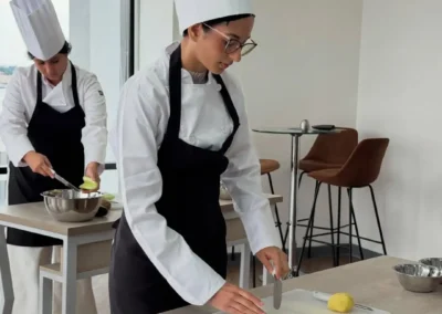 Estudiantes de Forever Culinary realizando práctica de cocina profesional en clase de gastronomía