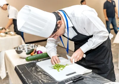 Estudiante realizando práctica culinaria en cocina profesional de Forever Culinary
